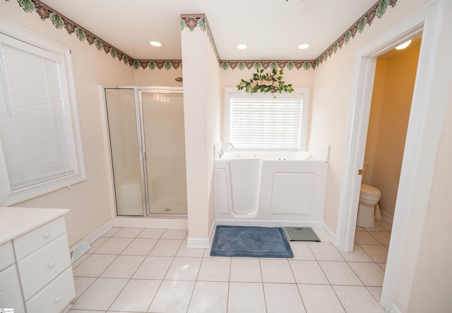 full bathroom with toilet, vanity, plus walk in shower, and tile patterned flooring