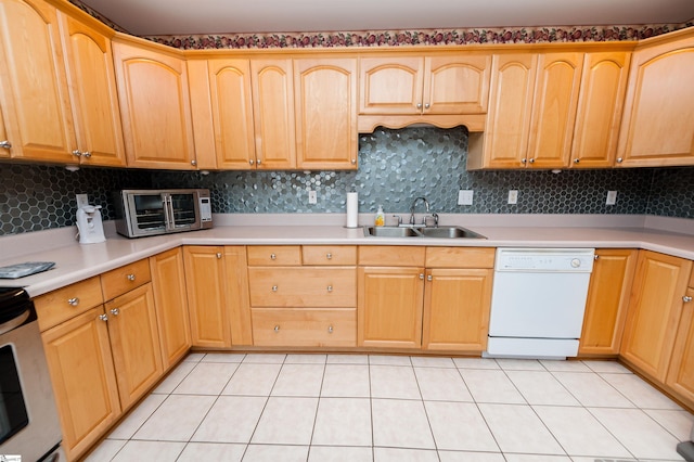 kitchen featuring dishwasher, sink, light tile patterned floors, and backsplash