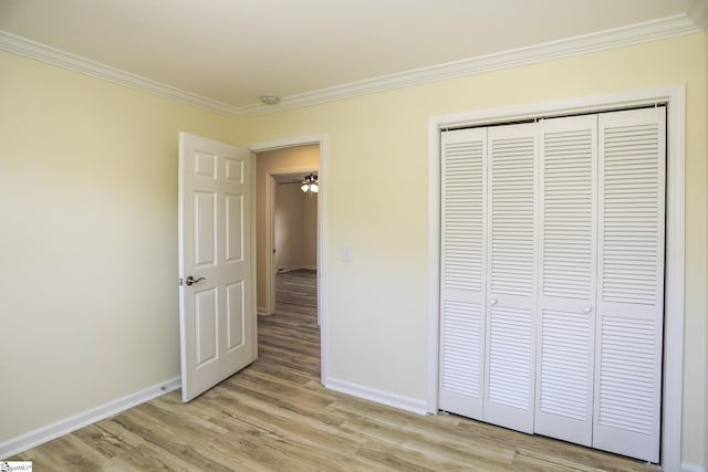 unfurnished bedroom with light wood-type flooring, a closet, and ornamental molding