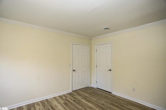 spare room featuring wood-type flooring and crown molding