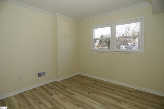 unfurnished room with light hardwood / wood-style floors and crown molding