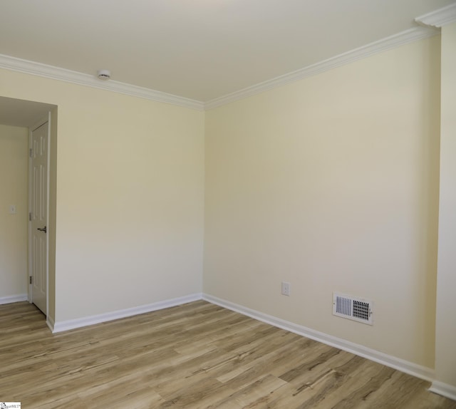 empty room featuring crown molding and light wood-type flooring