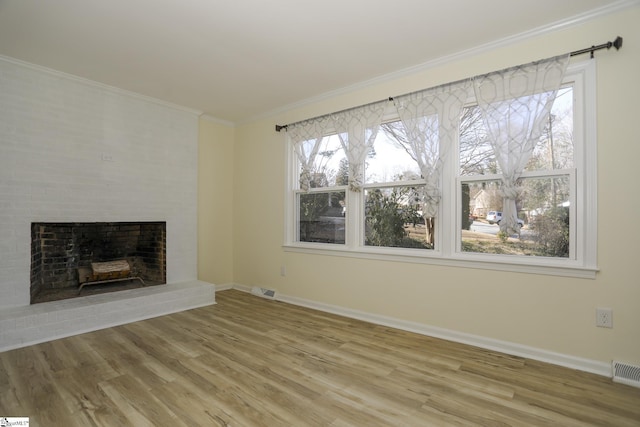 unfurnished living room featuring crown molding, a fireplace, and hardwood / wood-style flooring