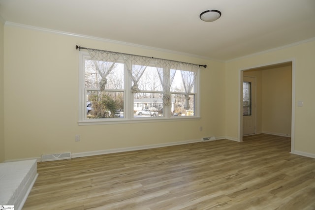 unfurnished room featuring ornamental molding and light wood-type flooring