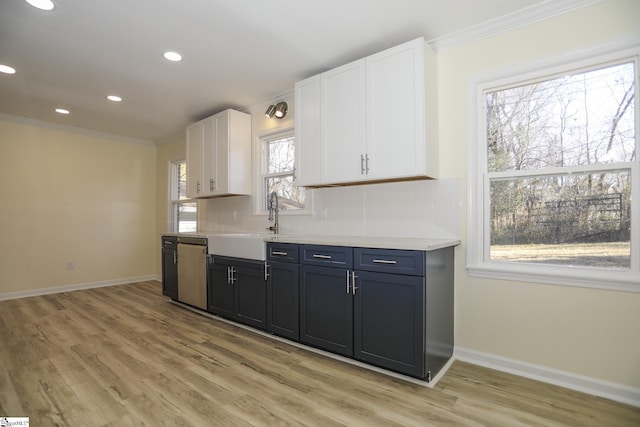 kitchen featuring a wealth of natural light, dishwasher, white cabinetry, light hardwood / wood-style floors, and sink