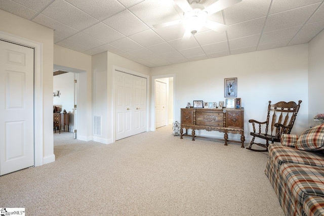 sitting room featuring carpet and ceiling fan