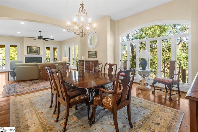 dining room featuring ceiling fan with notable chandelier and hardwood / wood-style floors