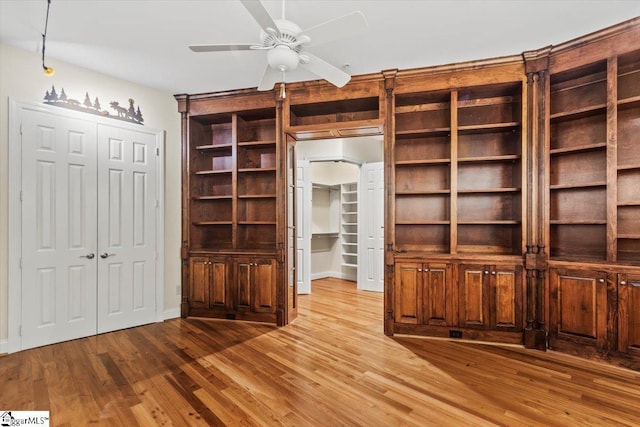 interior space with light hardwood / wood-style floors, built in features, and ceiling fan