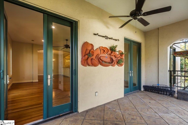 view of exterior entry featuring ceiling fan and a patio area