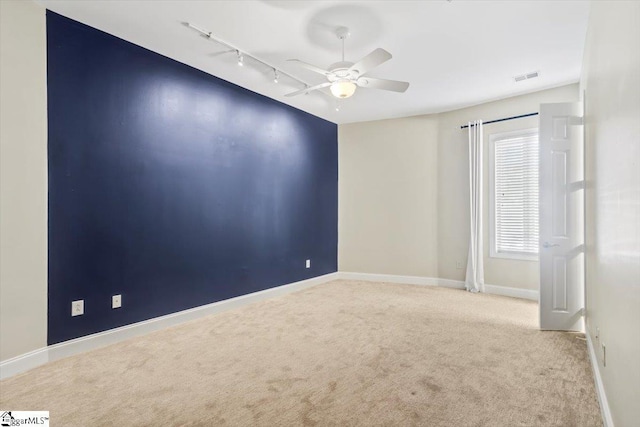 carpeted empty room with ceiling fan and track lighting