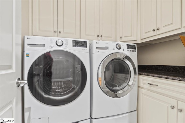 clothes washing area with washer and dryer and cabinets