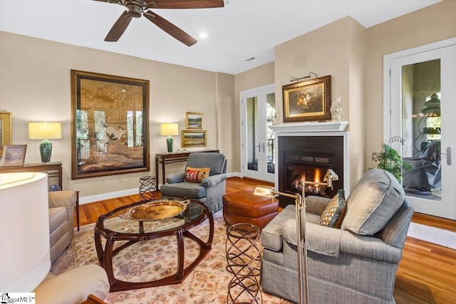 living room with ceiling fan, french doors, and light wood-type flooring