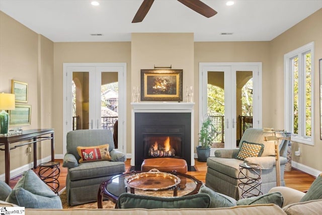 living area featuring ceiling fan, french doors, and light wood-type flooring