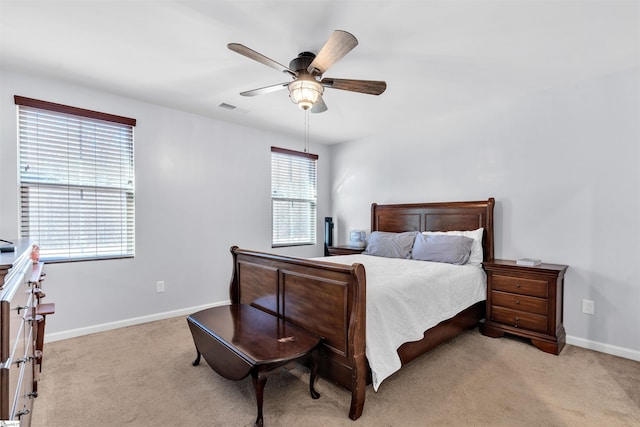 carpeted bedroom featuring ceiling fan and multiple windows