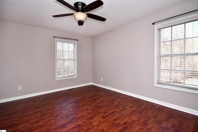 spare room featuring ceiling fan, dark wood-type flooring, and a textured ceiling