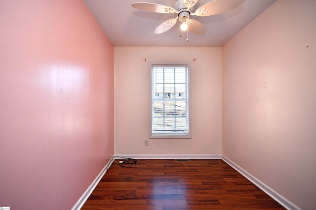 empty room with ceiling fan and dark hardwood / wood-style flooring