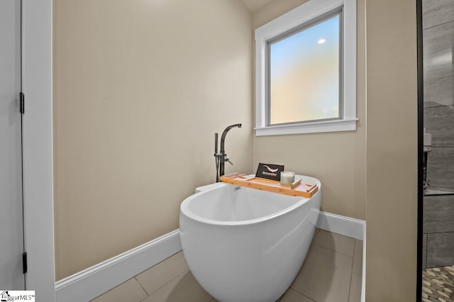 bathroom with tile patterned floors and a washtub