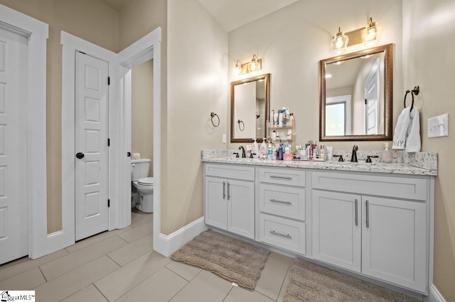 bathroom featuring toilet, vanity, and tile patterned floors