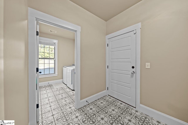 washroom with independent washer and dryer and light tile patterned flooring