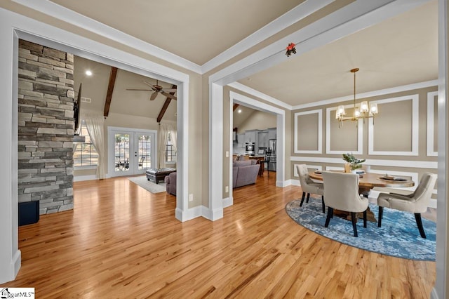 dining space with light wood-type flooring, ceiling fan with notable chandelier, french doors, and lofted ceiling with beams