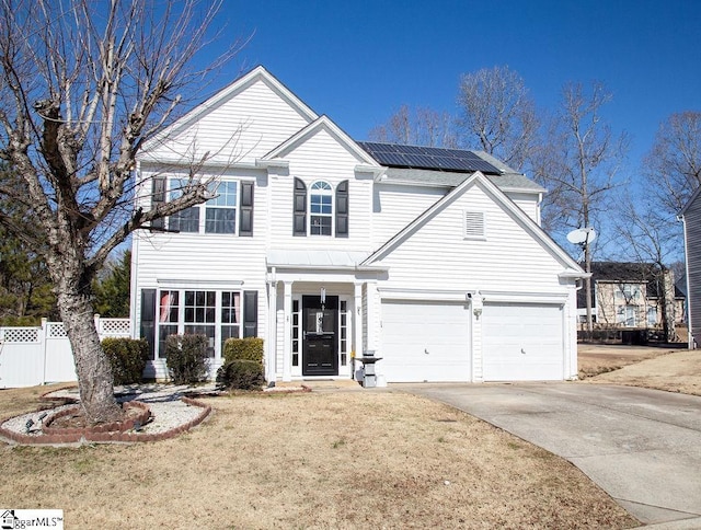 view of front of property featuring a front yard, a garage, and solar panels