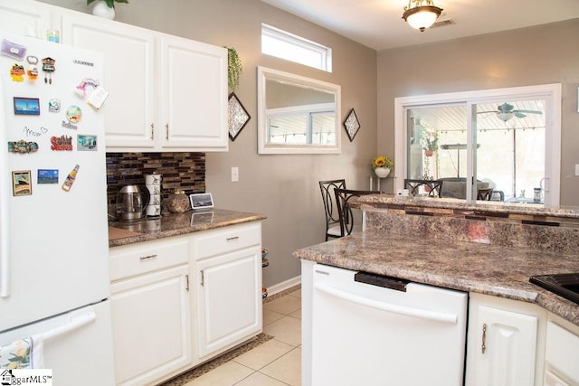 kitchen with light tile patterned floors, backsplash, white appliances, and white cabinetry