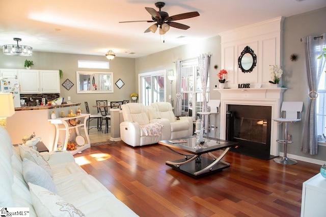 living room featuring ceiling fan, dark hardwood / wood-style floors, and a fireplace