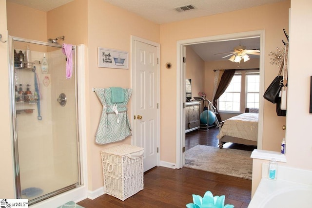 bathroom featuring ceiling fan, wood-type flooring, and an enclosed shower