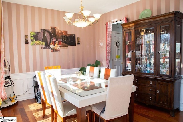 dining space with dark hardwood / wood-style flooring and a chandelier