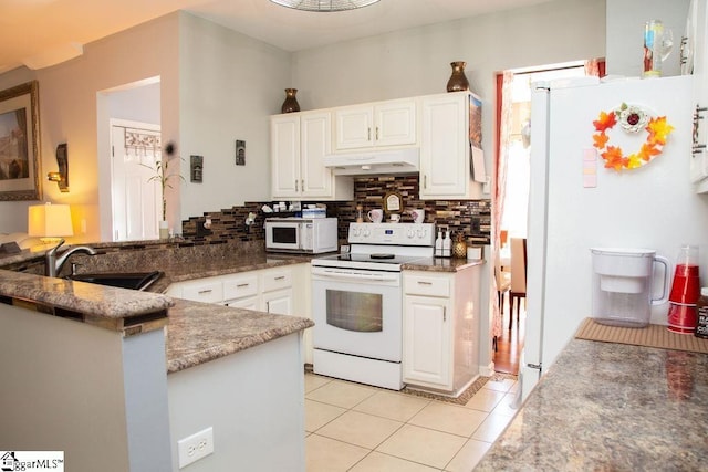 kitchen featuring white cabinetry, kitchen peninsula, tasteful backsplash, and white appliances