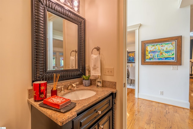 bathroom featuring hardwood / wood-style floors, vanity, and crown molding