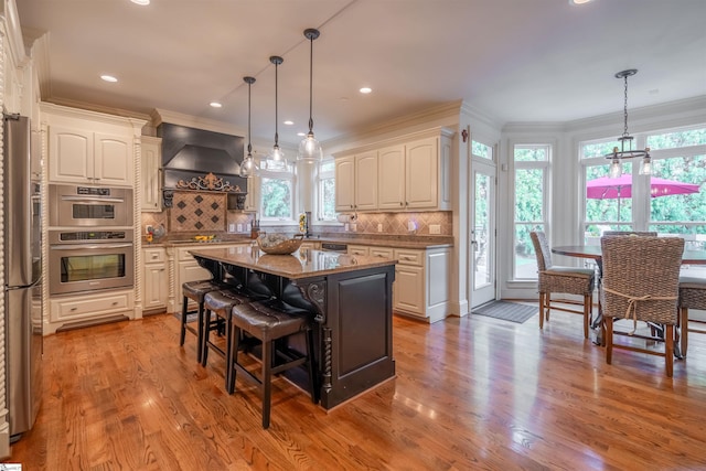 kitchen featuring a kitchen island, white cabinets, a breakfast bar, and light stone countertops