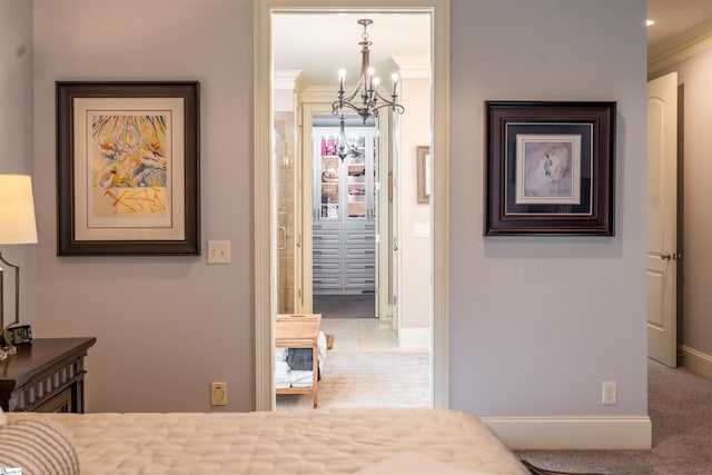 carpeted bedroom with ornamental molding and an inviting chandelier