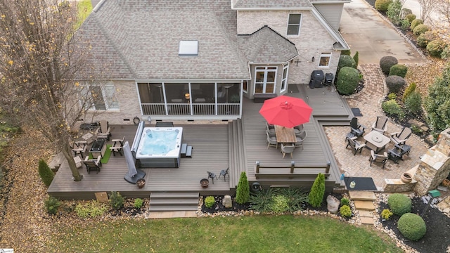 rear view of house featuring a wooden deck and a sunroom