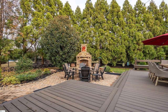 wooden deck featuring a patio area and an outdoor stone fireplace