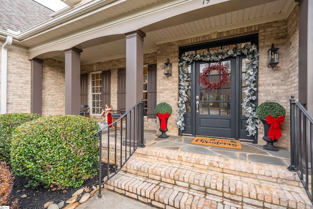 view of exterior entry featuring covered porch