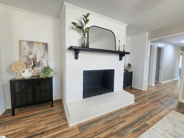 details with hardwood / wood-style flooring, crown molding, and a brick fireplace