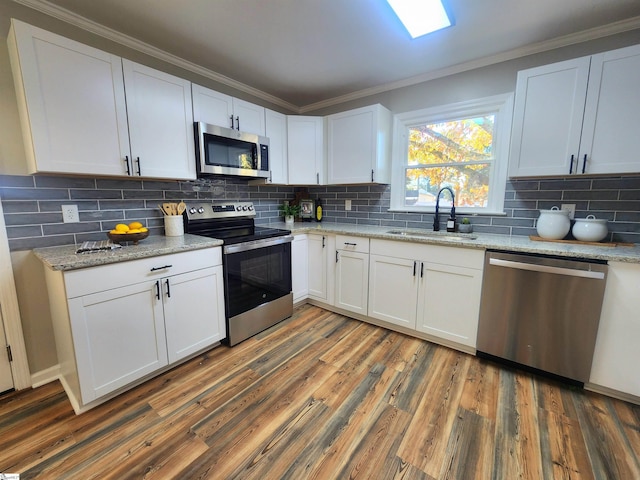 kitchen featuring stainless steel appliances, tasteful backsplash, dark wood-type flooring, white cabinets, and sink