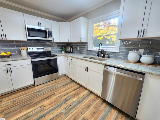 kitchen featuring decorative backsplash, sink, light hardwood / wood-style flooring, stainless steel appliances, and white cabinets