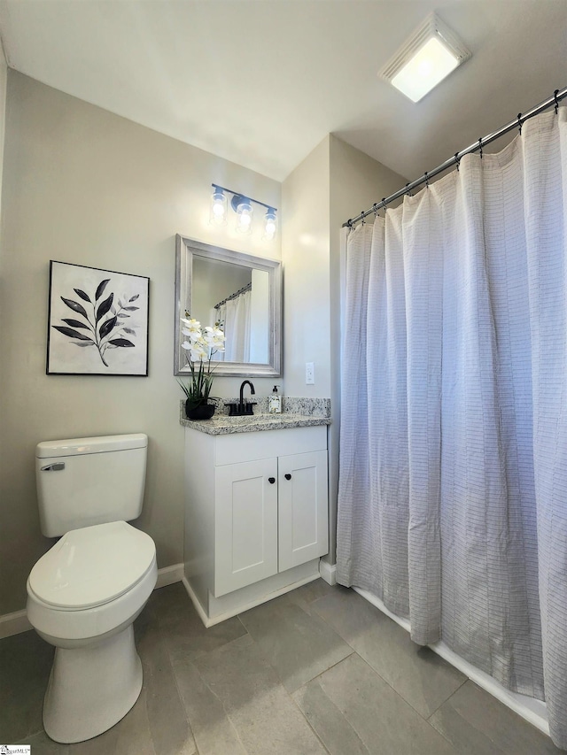 bathroom with toilet, vanity, and curtained shower