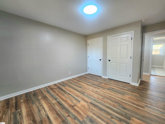 unfurnished bedroom with dark hardwood / wood-style floors