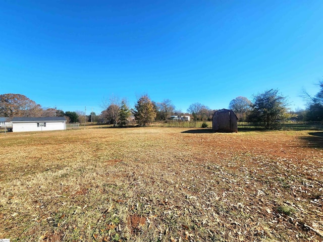 view of yard with a rural view and a shed