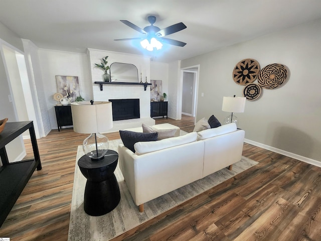 living room with ceiling fan, dark hardwood / wood-style floors, and a fireplace