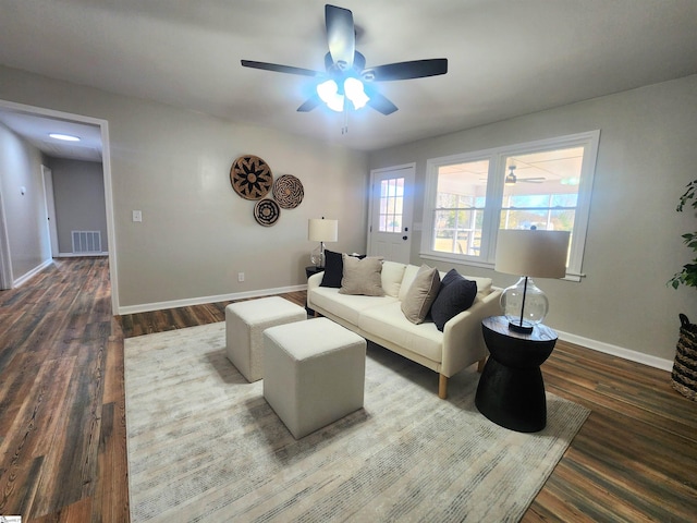 living room featuring ceiling fan and dark wood-type flooring