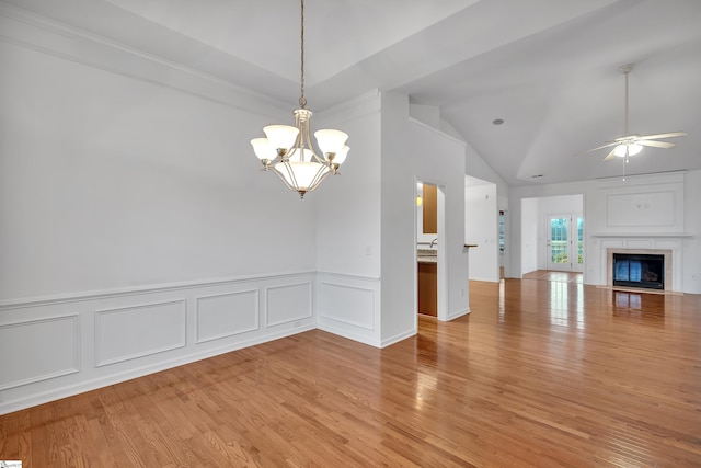 unfurnished living room featuring vaulted ceiling, ceiling fan with notable chandelier, and light wood-type flooring