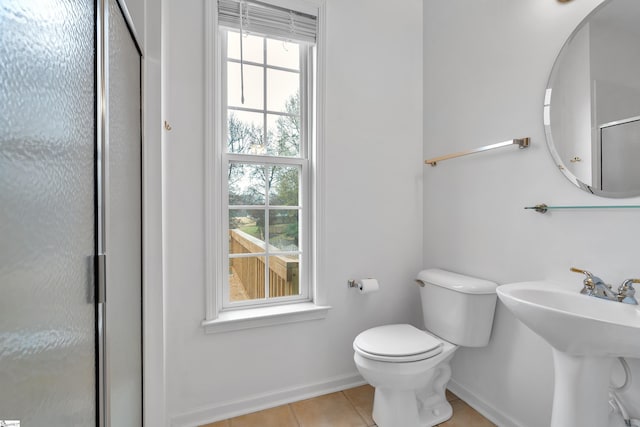 bathroom with toilet, sink, an enclosed shower, and tile patterned floors