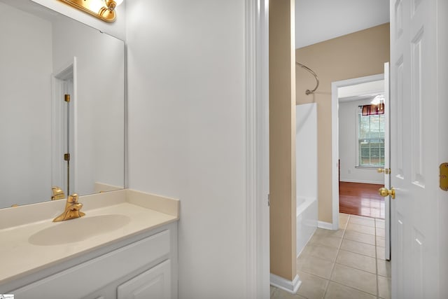 bathroom with tile patterned flooring, tub / shower combination, and vanity