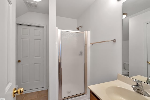 bathroom with an enclosed shower, vanity, toilet, and tile patterned flooring