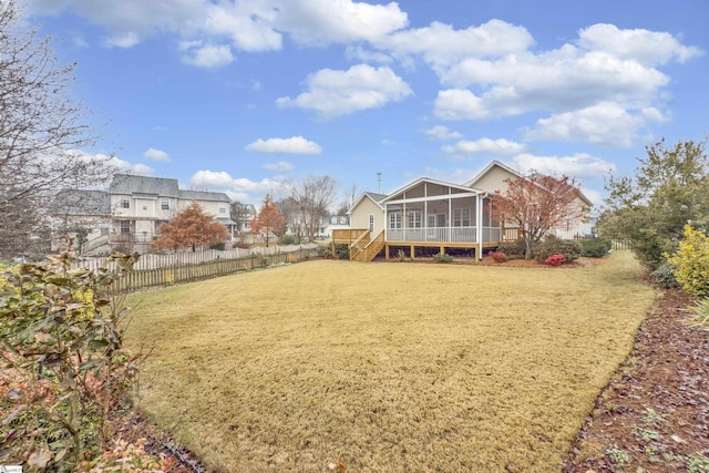 back of property featuring a lawn and a sunroom