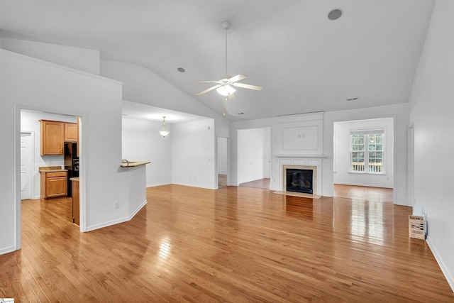 unfurnished living room featuring vaulted ceiling, ceiling fan, and light hardwood / wood-style flooring